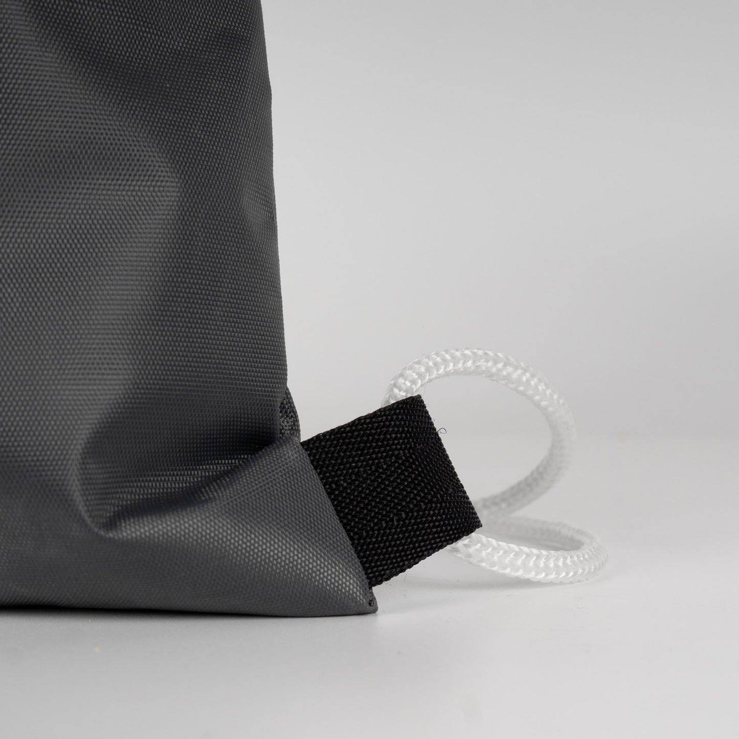 Estetik ve derin antrasit büzgülü çanta, hafif damlalarla modern outdoor görünüm.