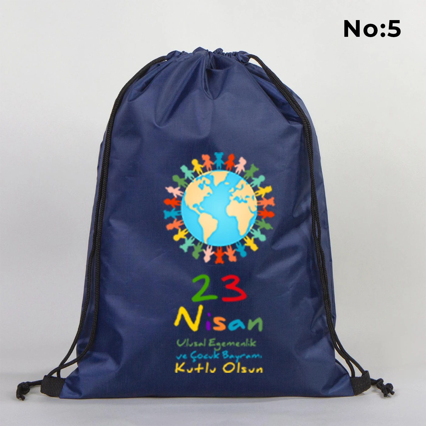 32x45 cm lacivert büzgülü sırt çantası üzerinde “Yaşasın 23 Nisan” yazılı çocuk temalı renkli baskı, roket ve kâğıt uçak detayları, kutlama temalı sınıf arka planı