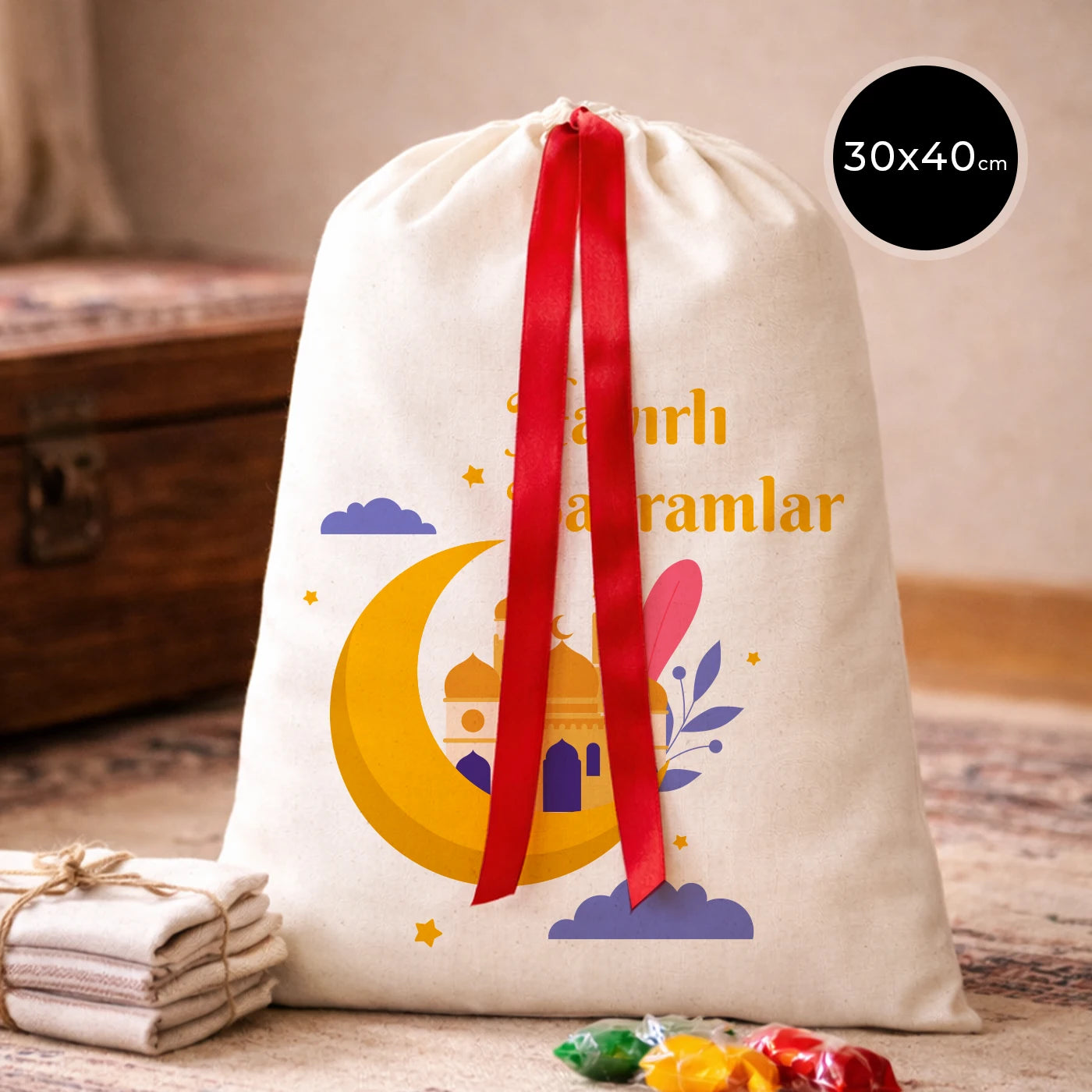 30x40 cm ölçülerinde, kırmızı kurdelalı, ay ve cami figürlü ‘İyi Bayramlar’ baskılı bez kese bayram çantası