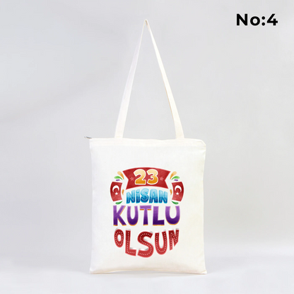 35x40 cm fermuarlı ham bez çanta üzerinde dünya etrafında renkli çocuk figürleri ve “23 Nisan Ulusal Egemenlik ve Çocuk Bayramı Kutlu Olsun” yazısı bulunan 23 Nisan temalı bez çanta.
