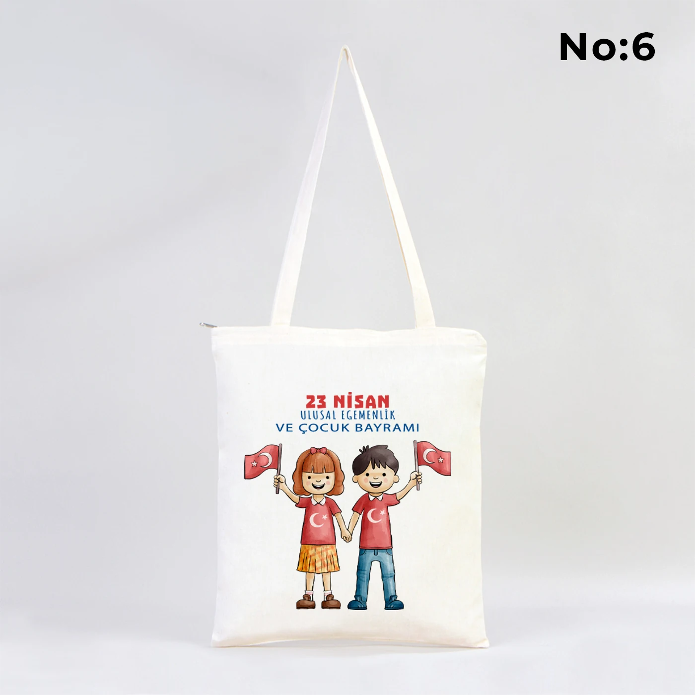 35x40 cm fermuarlı ham bez çanta üzerinde dünya etrafında renkli çocuk figürleri ve “23 Nisan Ulusal Egemenlik ve Çocuk Bayramı Kutlu Olsun” yazısı bulunan 23 Nisan temalı bez çanta.