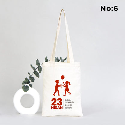 20x25 cm ham bez çocuk çantası üzerinde “Yaşasın 23 Nisan” yazısı ve dünya üzerinde oynayan çocuk illüstrasyonu bulunan 23 Nisan temalı bez çanta.
