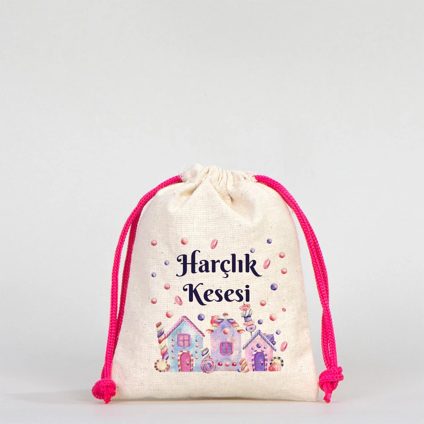 Beyaz arka planda, fuşya büzgülü ipli, pamuk kumaş bayram harçlık kesesi, üzerinde sevimli ev ve şeker desenleri ile “Harçlık Kesesi” yazısı