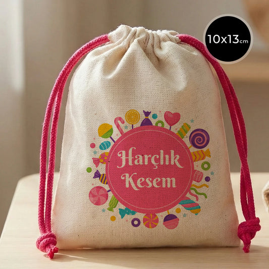 Fuşya ipli, 10x13 cm ölçülerinde, pamuk bezden yapılmış, üzerinde renkli şeker desenleri ve “Harçlık Kesem” yazısı bulunan bayram harçlık kesesi