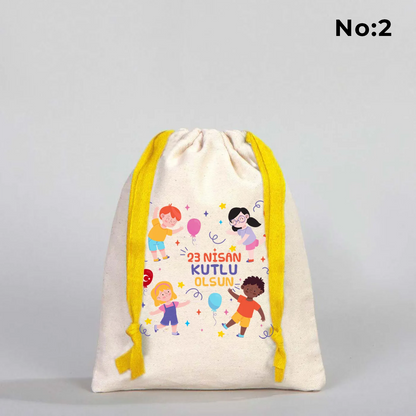 15x20 cm naturel renkli, sarı büzgü ipli bez kese üzerinde dünya figürü, renkli çocuk silüetleri ve “23 Nisan Ulusal Egemenlik ve Çocuk Bayramı Kutlu Olsun” yazılı baskı