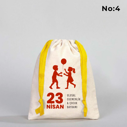 15x20 cm naturel renkli, sarı büzgü ipli bez kese üzerinde dünya figürü, renkli çocuk silüetleri ve “23 Nisan Ulusal Egemenlik ve Çocuk Bayramı Kutlu Olsun” yazılı baskı