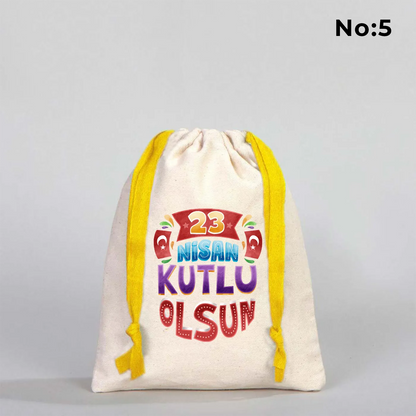 15x20 cm naturel renkli, sarı büzgü ipli bez kese üzerinde dünya figürü, renkli çocuk silüetleri ve “23 Nisan Ulusal Egemenlik ve Çocuk Bayramı Kutlu Olsun” yazılı baskı