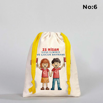 15x20 cm naturel renkli, sarı büzgü ipli bez kese üzerinde dünya figürü, renkli çocuk silüetleri ve “23 Nisan Ulusal Egemenlik ve Çocuk Bayramı Kutlu Olsun” yazılı baskı