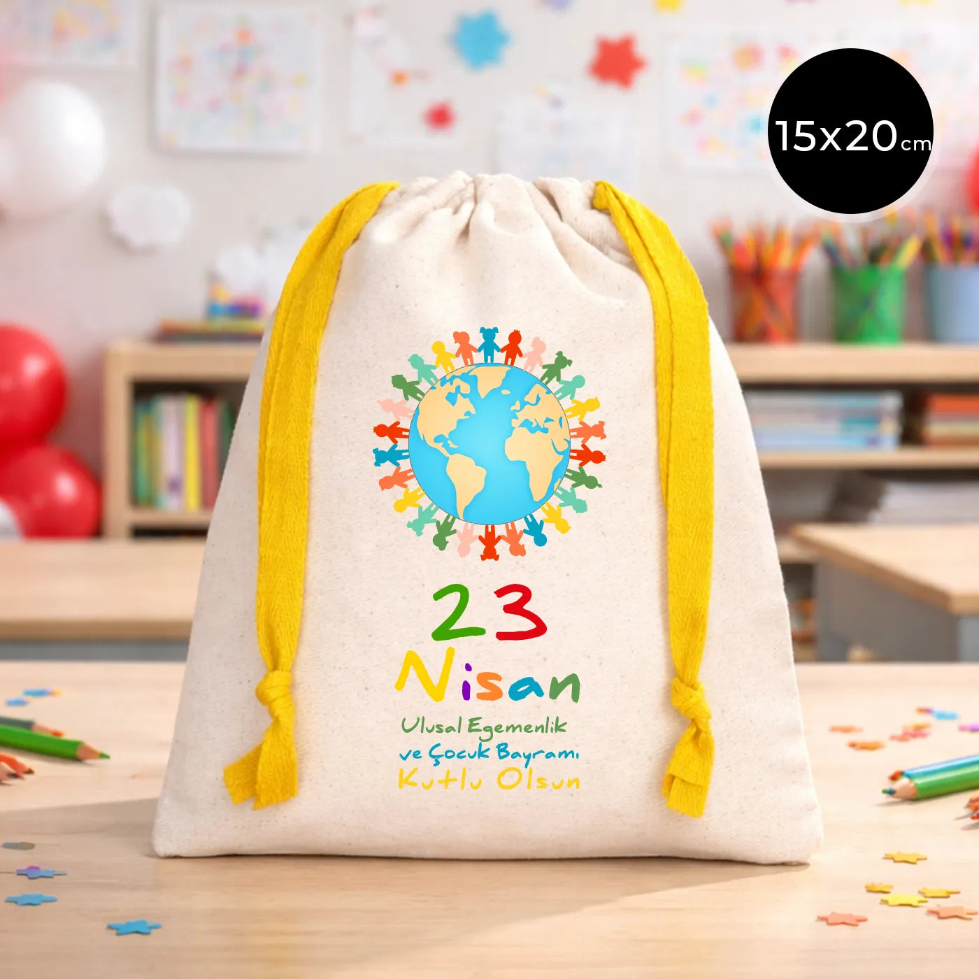 15x20 cm naturel renkli, sarı büzgü ipli bez kese üzerinde dünya figürü, renkli çocuk silüetleri ve “23 Nisan Ulusal Egemenlik ve Çocuk Bayramı Kutlu Olsun” yazılı baskı