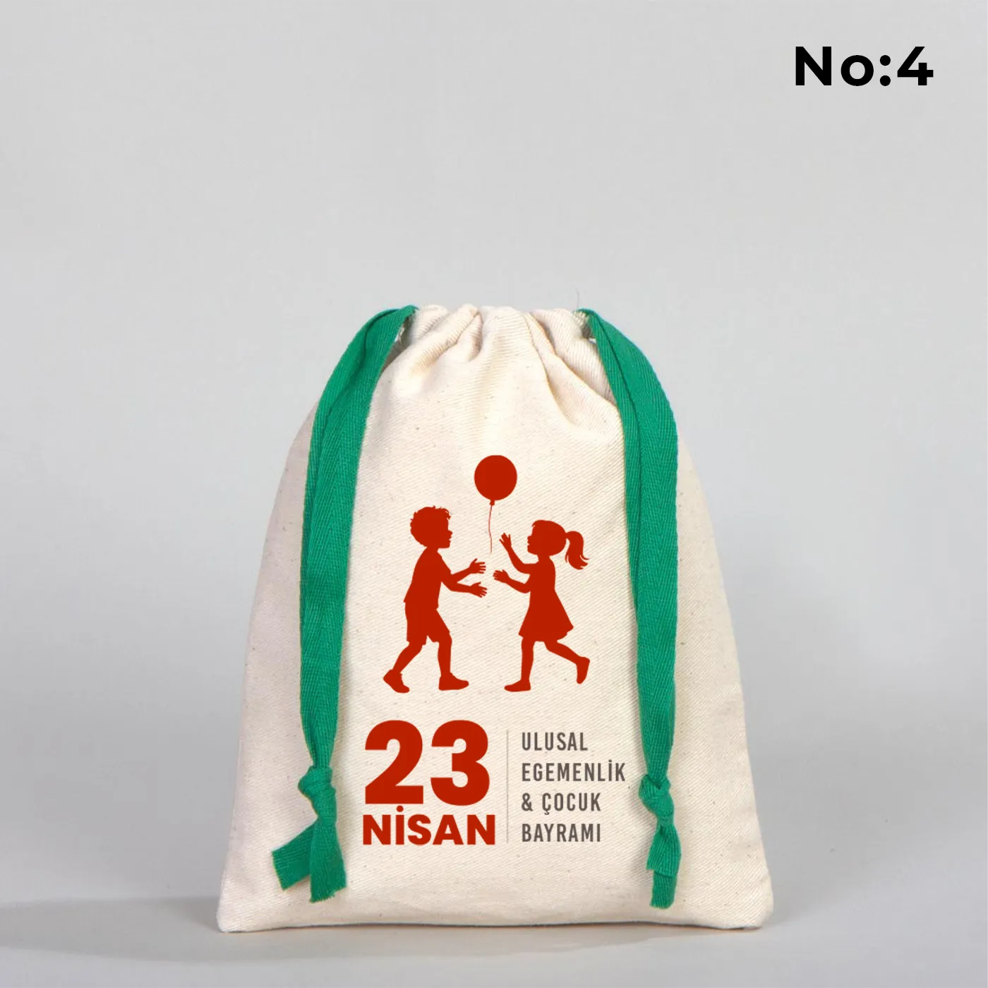 Naturel renkli, yeşil büzgü ipli bez kese üzerinde “Yaşasın 23 Nisan” yazılı çocuk temalı renkli baskı, roket ve kâğıt uçak detayları