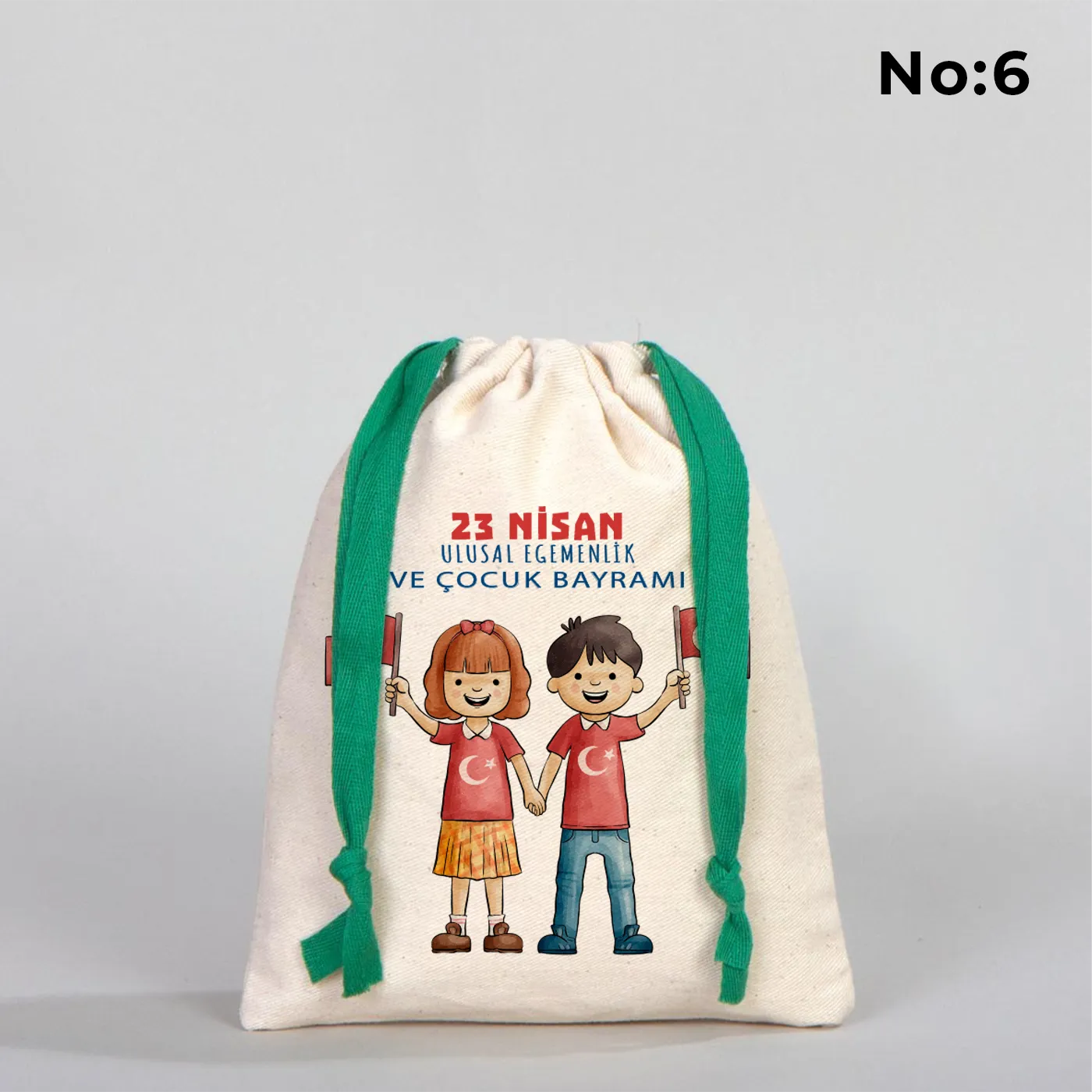 Naturel renkli, yeşil büzgü ipli bez kese üzerinde “Yaşasın 23 Nisan” yazılı çocuk temalı renkli baskı, roket ve kâğıt uçak detayları