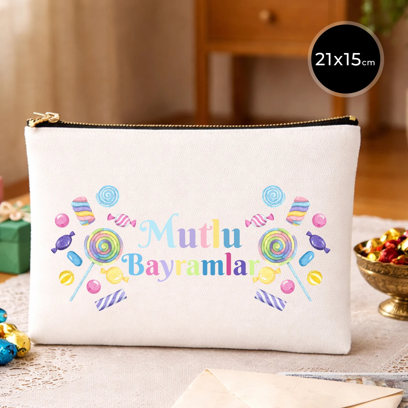 Krem kanvas 21x15 cm elde taşınabilir clutch, siyah fermuarlı, “Mutlu Bayramlar” yazısı ve şeker motifleri bulunan Bayram hediyelik çanta