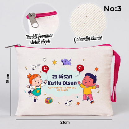 23 Nisan temalı 21x15 cm fermuarlı bez kalemlik üzerinde “23 Nisan Ulusal Egemenlik ve Çocuk Bayramı Kutlu Olsun” yazısı, ay ve yıldız üzerinde oturan iki çocuk illüstrasyonu ve okul - sınıf özelleştirilebilir alan.