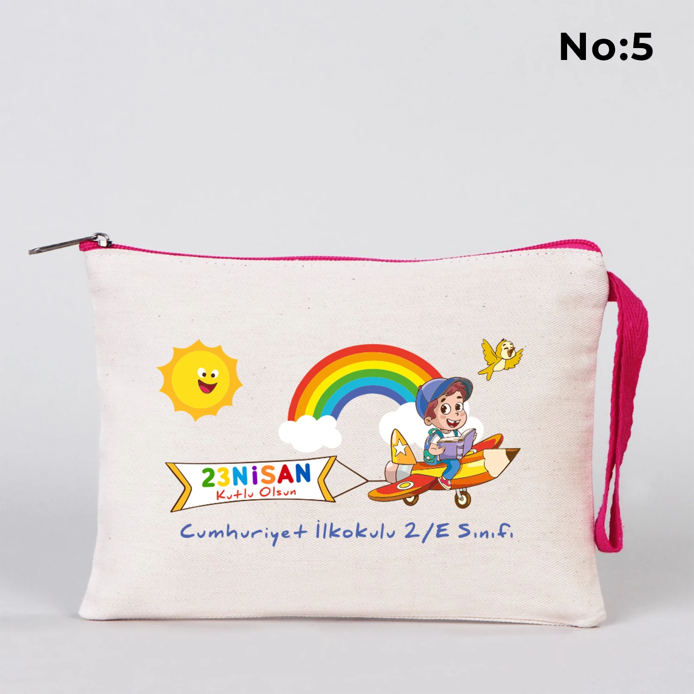 23 Nisan temalı 21x15 cm fermuarlı bez kalemlik üzerinde “23 Nisan Ulusal Egemenlik ve Çocuk Bayramı Kutlu Olsun” yazısı, ay ve yıldız üzerinde oturan iki çocuk illüstrasyonu ve okul - sınıf özelleştirilebilir alan.