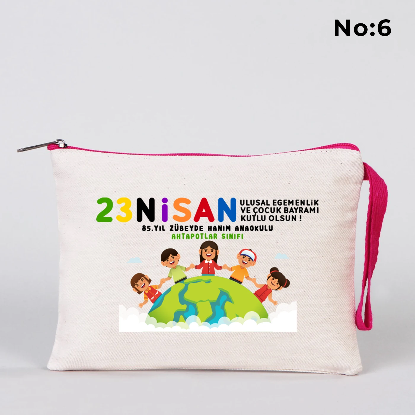 23 Nisan temalı 21x15 cm fermuarlı bez kalemlik üzerinde “23 Nisan Ulusal Egemenlik ve Çocuk Bayramı Kutlu Olsun” yazısı, ay ve yıldız üzerinde oturan iki çocuk illüstrasyonu ve okul - sınıf özelleştirilebilir alan.