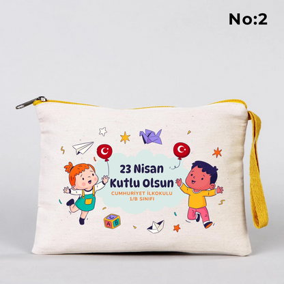 23 Nisan temalı 21x15 cm fermuarlı bez kalemlik üzerinde dünya etrafında el ele çocuk figürleri, “23 Nisan Ulusal Egemenlik ve Çocuk Bayramı Kutlu Olsun” yazısı ve okul - sınıf özelleştirilebilir alan.
