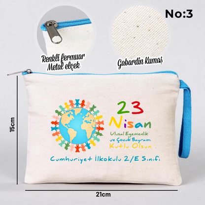 23 Nisan temalı 21x15 cm fermuarlı bez kalemlik üzerinde “23 Nisan Ulusal Egemenlik ve Çocuk Bayramı Kutlu Olsun” yazısı, ay ve yıldız üzerinde oturan iki çocuk illüstrasyonu ve okul - sınıf özelleştirilebilir alan.