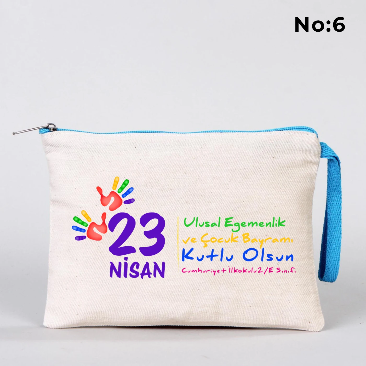 23 Nisan temalı 21x15 cm fermuarlı bez kalemlik üzerinde “23 Nisan Ulusal Egemenlik ve Çocuk Bayramı Kutlu Olsun” yazısı, ay ve yıldız üzerinde oturan iki çocuk illüstrasyonu ve okul - sınıf özelleştirilebilir alan.