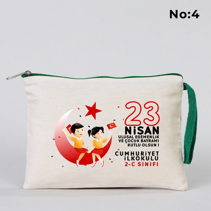 23 Nisan temalı 21x15 cm fermuarlı bez kalemlik üzerinde gökkuşağı, güneş ve uçaklı çocuk illüstrasyonu ile “23 Nisan Kutlu Olsun” yazısı ve okul - sınıf özelleştirilebilir alan.