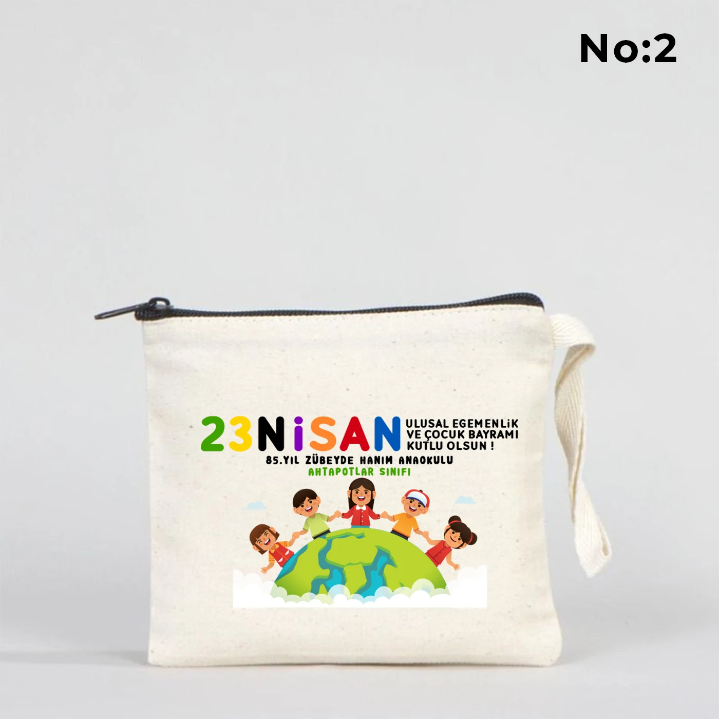 23 Nisan temalı 15x13 cm fermuarlı bez kalemlik üzerinde “23 Nisan Kutlu Olsun” yazısı, balonlu iki çocuk illüstrasyonu ve okul - sınıf özelleştirilebilir alan.