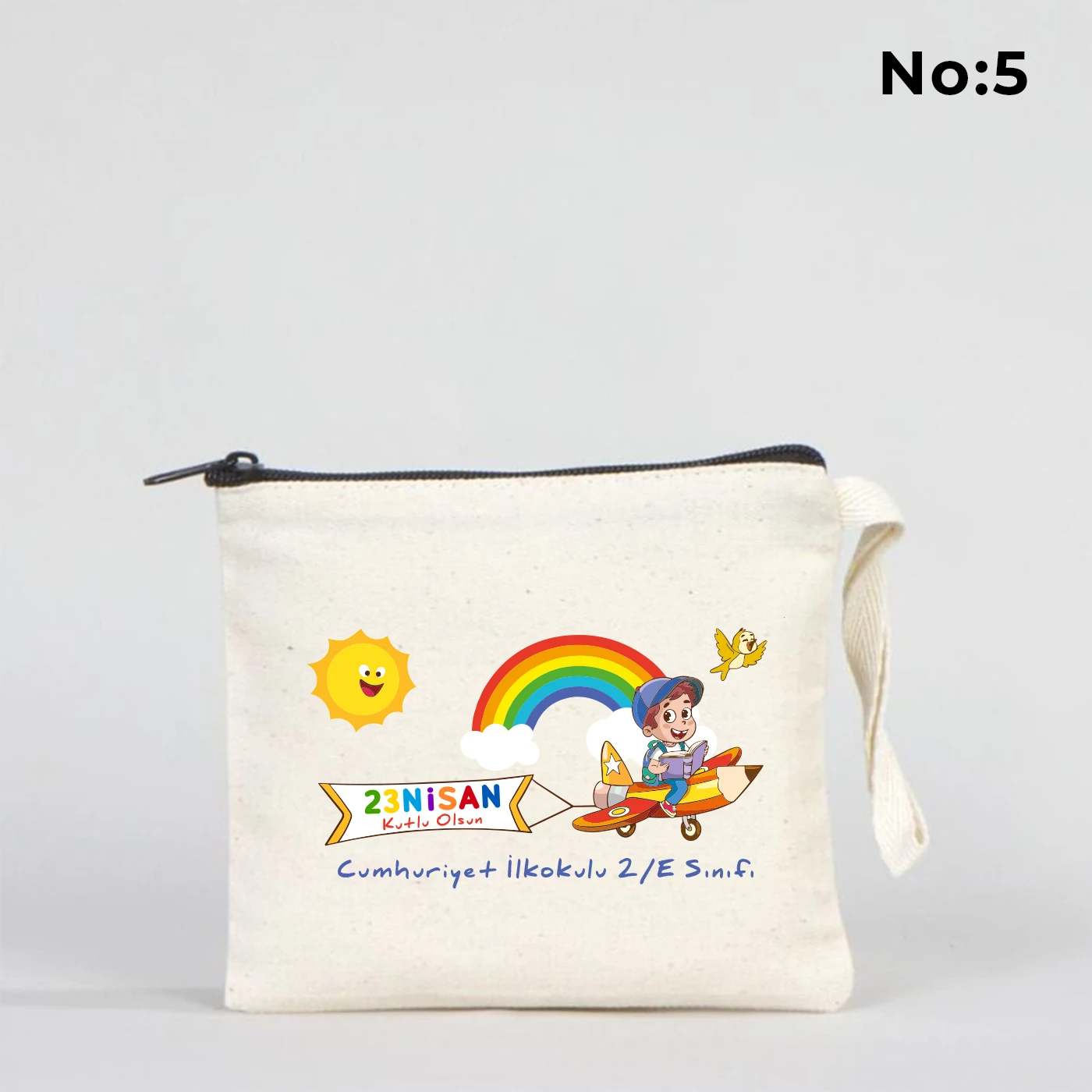 23 Nisan temalı 15x13 cm fermuarlı bez kalemlik üzerinde “23 Nisan Kutlu Olsun” yazısı, balonlu iki çocuk illüstrasyonu ve okul - sınıf özelleştirilebilir alan.