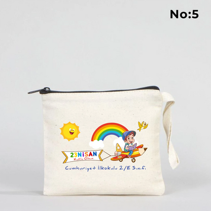 23 Nisan temalı 15x13 cm fermuarlı bez kalemlik üzerinde “23 Nisan Kutlu Olsun” yazısı, balonlu iki çocuk illüstrasyonu ve okul - sınıf özelleştirilebilir alan.