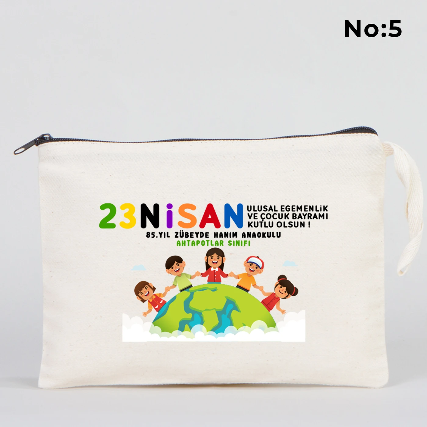 25x18 cm krem renkli fermuarlı kumaş kalemlik üzerinde 23 Nisan Ulusal Egemenlik ve Çocuk Bayramı baskısı, ay yıldız üzerinde oturan iki çocuk illüstrasyonu ve sınıf temalı arka plan
