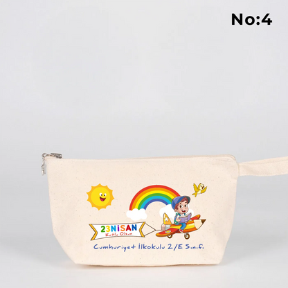 22x12x5 cm krem renkli fermuarlı kumaş kalemlik üzerinde yıldız fermuar ucu detayı, dünya figürü, renkli çocuk silüetleri ve “23 Nisan Ulusal Egemenlik ve Çocuk Bayramı Kutlu Olsun” yazılı baskı