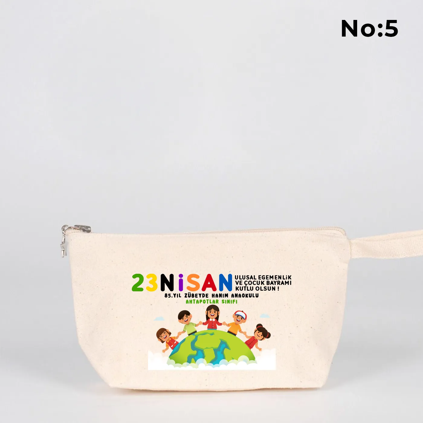 22x12x5 cm krem renkli fermuarlı kumaş kalemlik üzerinde yıldız fermuar ucu detayı, dünya figürü, renkli çocuk silüetleri ve “23 Nisan Ulusal Egemenlik ve Çocuk Bayramı Kutlu Olsun” yazılı baskı