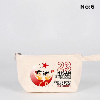 22x12x5 cm krem renkli fermuarlı kumaş kalemlik üzerinde yıldız fermuar ucu detayı, dünya figürü, renkli çocuk silüetleri ve “23 Nisan Ulusal Egemenlik ve Çocuk Bayramı Kutlu Olsun” yazılı baskı