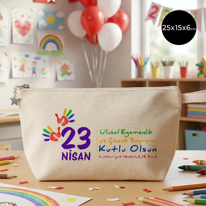 25x15x6 cm krem renkli fermuarlı kumaş kalemlik üzerinde yıldız fermuar ucu detayı, renkli “23 Nisan Ulusal Egemenlik ve Çocuk Bayramı Kutlu Olsun” yazılı baskı ve el izi figürleri