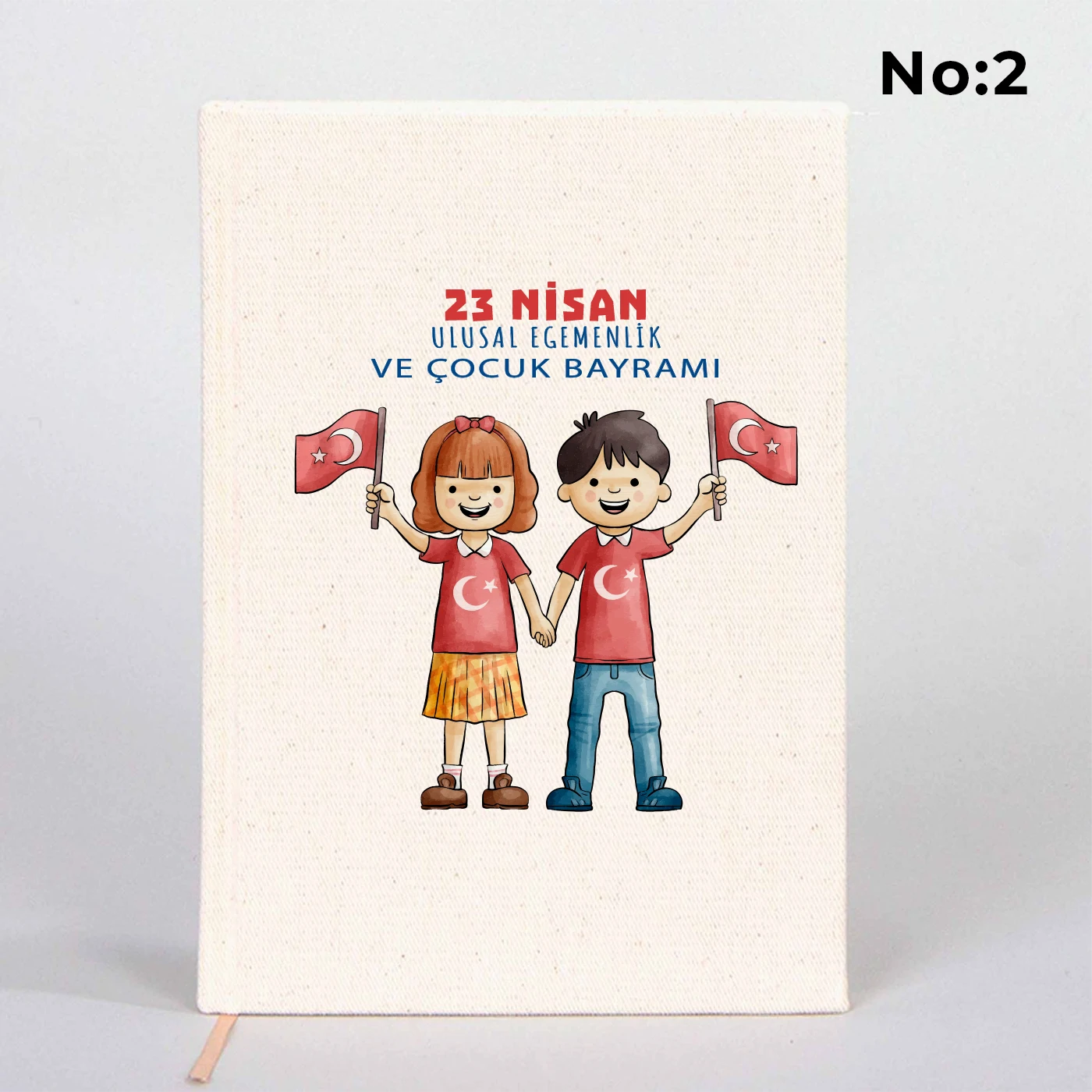 14x20 cm bez kaplı defter üzerinde renkli “23 Nisan Kutlu Olsun” yazı tasarımı bulunan çocuk temalı hediye defter.
