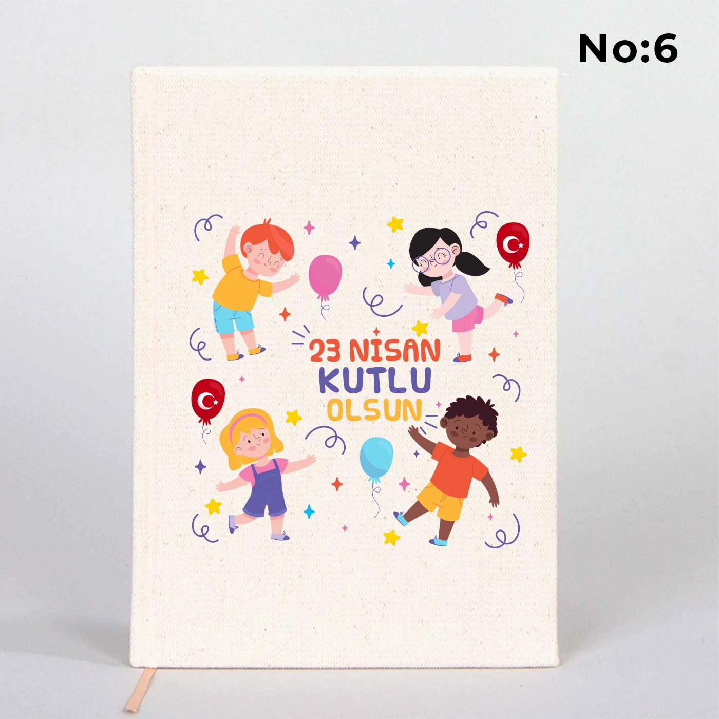 14x20 cm bez kaplı defter üzerinde renkli “23 Nisan Kutlu Olsun” yazı tasarımı bulunan çocuk temalı hediye defter.