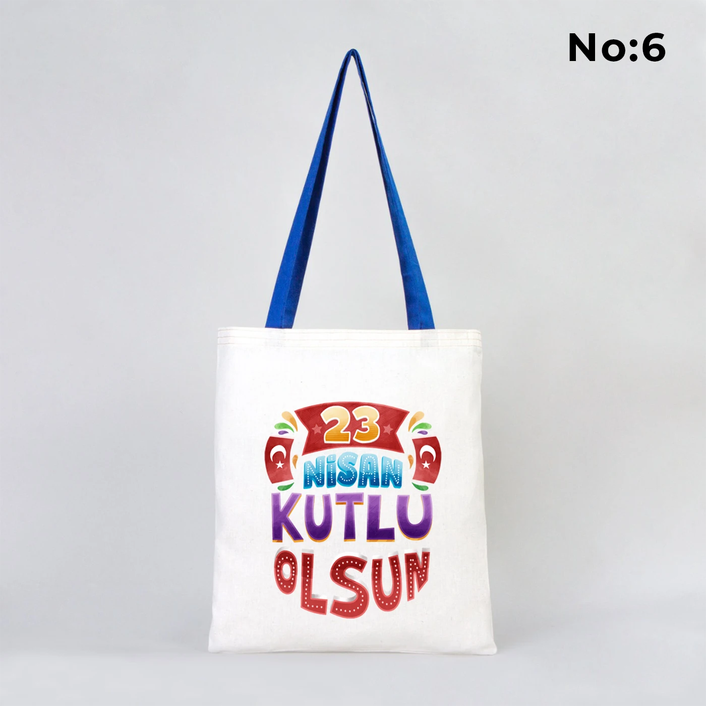 35x40 cm ham bez çanta üzerinde dünya etrafında renkli çocuk figürleri ve “23 Nisan Ulusal Egemenlik ve Çocuk Bayramı Kutlu Olsun” yazısı bulunan, mavi kulplu 23 Nisan temalı bez çanta.