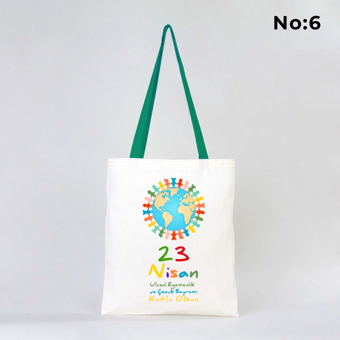 35x40 cm ham bez çanta üzerinde “23 Nisan Ulusal Egemenlik ve Çocuk Bayramı” yazısı ve Türk bayraklı kız-erkek çocuk illüstrasyonu bulunan, yeşil kulplu 23 Nisan temalı bez çanta.