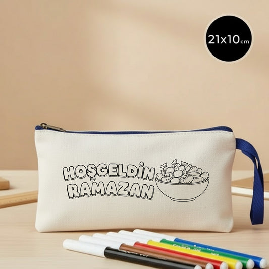 21x10 cm boyanabilir ham bez kese; saks mavi fermuarlı ve bilek askılı model, üzerinde çizgi çalışmasıyla “Hoş Geldin Ramazan” yazısı ve hurma kâsesi çizimi bulunan, çocuklar için boyama yapılabilen bayram harçlık cüzdanı.