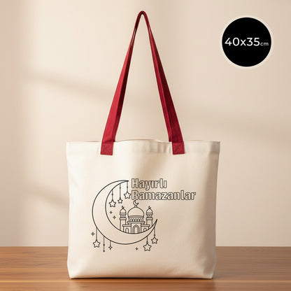 Boyanabilir 40x35 cm gabardin bez tote çanta; kırmızı uzun kulplu, ham renk kumaş üzerinde ay-yıldız detaylı cami çizimi ve “Hayırlı Ramazanlar” yazısı bulunan, günlük kullanım için uygun bayram harçlığı kesesi / hediyelik bez çanta.