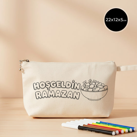 22x12x5 cm boyanabilir körüklü kanvas kalemlik; ham renk pamuk kumaş, fermuarlı ve bileklik askılı pouch modeli; üzerinde “Hoşgeldin Ramazan” yazısı ve kaseli şeker/kuruyemiş çizimi bulunan, Bayram ve Ramazan dönemi için hediyelik kalemlik/mini organizer çantası.
