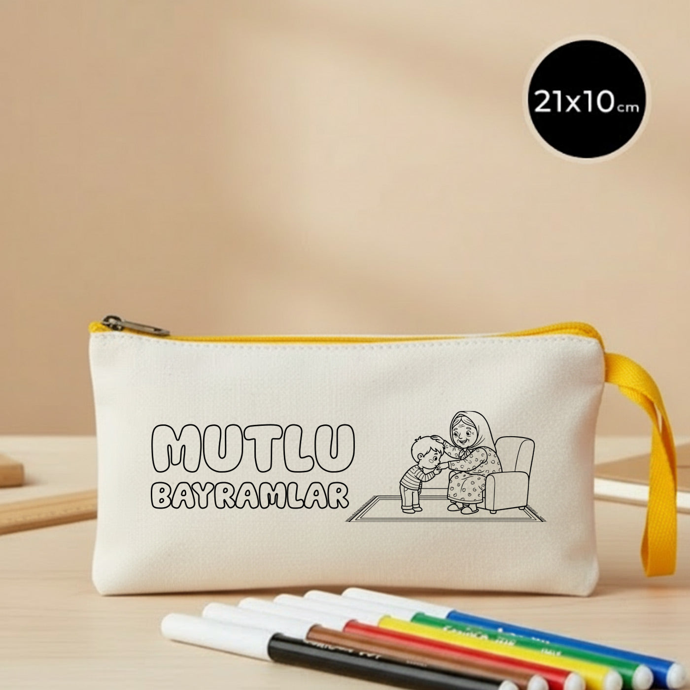 21x10 cm boyanabilir ham bez kalemlik; sarı fermuarlı ve bilek askılı model, üzerinde çizgi çalışmasıyla “Mutlu Bayramlar” yazısı ile koltukta oturan büyükanne ve elini öpen çocuk çizimi bulunan, çocuklar için boyama yapılabilen bayram kesesi.
