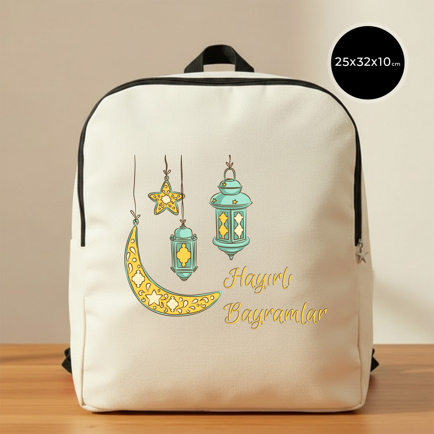 25×32×10 cm ölçülerinde doğal ham bez sırt çantası, siyah fermuar ve askılarla; ön yüzünde asılı turkuaz fenerler, süslemeli sarı hilal ve yıldız illüstrasyonu ile sağ altta “Hayırlı Bayramlar” yazısı, sade açık renkli arka plan ve ahşap yüzey.