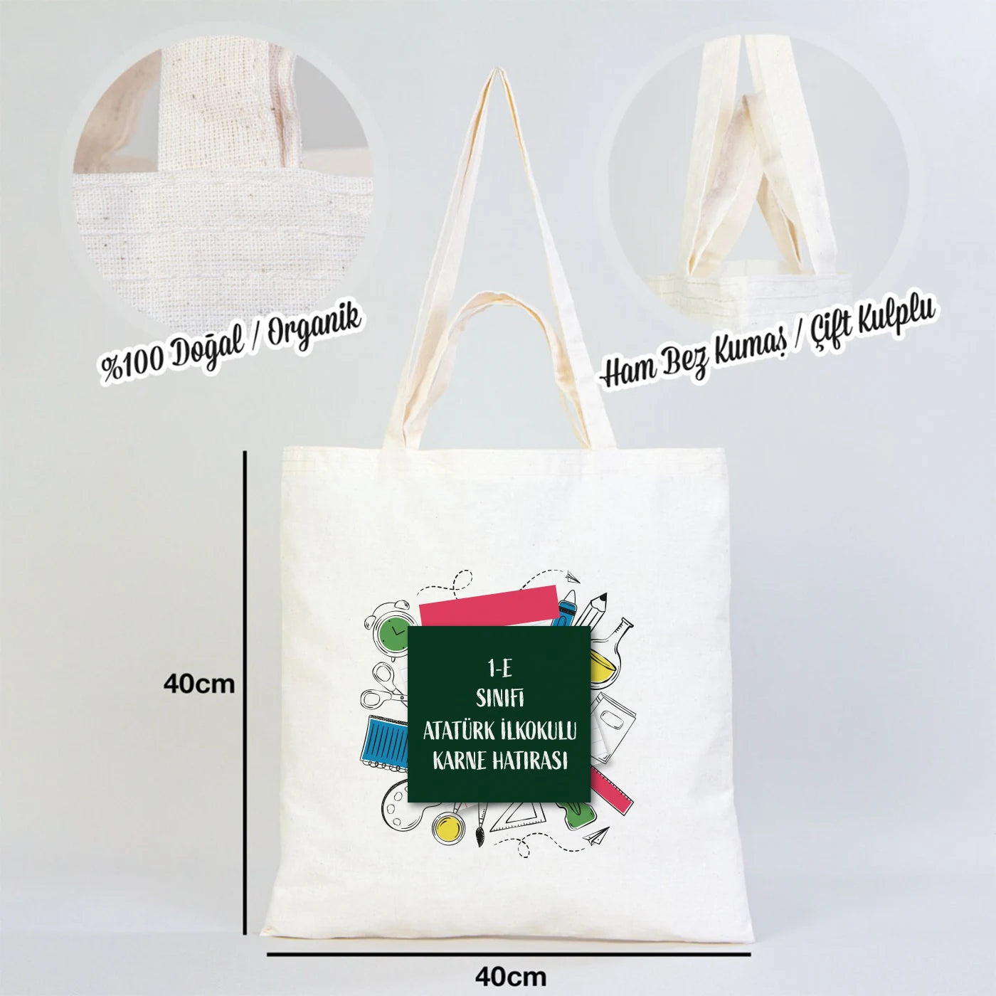 Rengarenk bir sınıf ortamında, ahşap masada sergilenen 40x40 cm çift kulplu ham pamuk bez çanta, 38 cm kısa ve 70 cm uzun saplı.