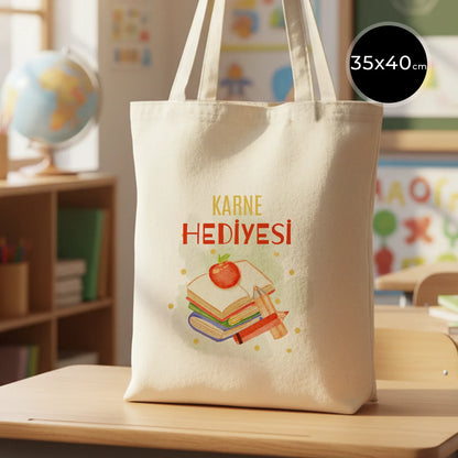 Sıcak ve renkli bir sınıf ortamında ahşap masada sergilenen 35x40 cm ham pamuk bez çanta, 70 cm saplı ve doğal görünümlü.