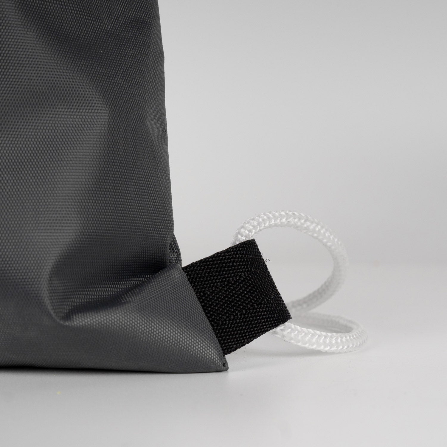 Estetik ve derin antrasit büzgülü çanta, hafif damlalarla modern outdoor görünüm.