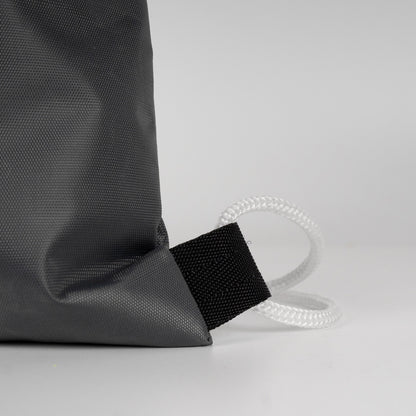 Estetik ve derin antrasit büzgülü çanta, hafif damlalarla modern outdoor görünüm.