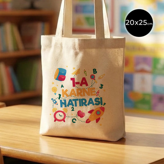 Sıcak ve renkli bir sınıf ortamında, ahşap masada sergilenen 20x25 cm ham pamuk bez çanta, 50 cm saplı ve doğal görünümlü.