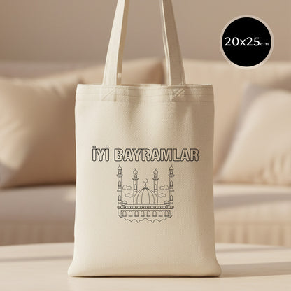 20x25 cm boyanabilir ham bez mini kitap çantası (küçük tote), uzun saplı doğal kumaş; ön yüzünde “İYİ BAYRAMLAR” yazısı ve cami çizimi bulunan bayram harçlığı/hediyelik bez çanta.