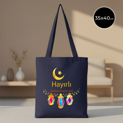 35x40 cm lacivert gabardin bez tote çanta; ön yüzde altın hilal-yıldız, “Hayırlı Ramazanlar” yazısı ve üç renkli ramazan feneri baskısı.