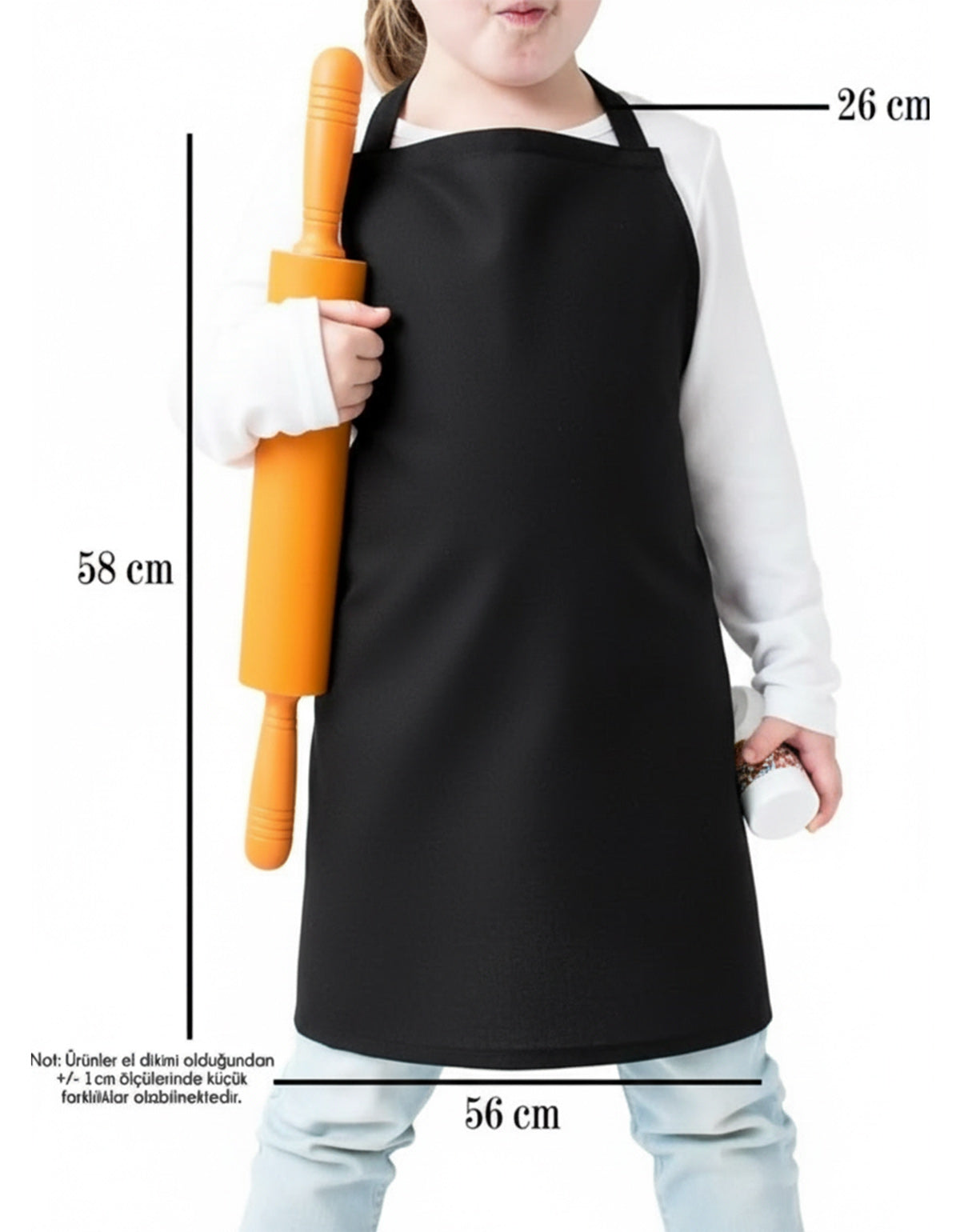 Siyah çocuk mutfak önlüğü giyen çocuk model; bir elinde turuncu merdane tutarken, sade ve baskısız önlük ön görünümde gösterilmektedir.