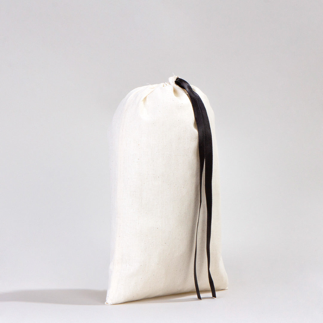 Siyah kurdeleli pamuk bez kese modeli, sade beyaz arka planda ayakta duran büzgülü kese,.